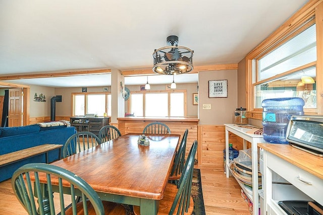 dining area with light hardwood / wood-style floors and a wood stove