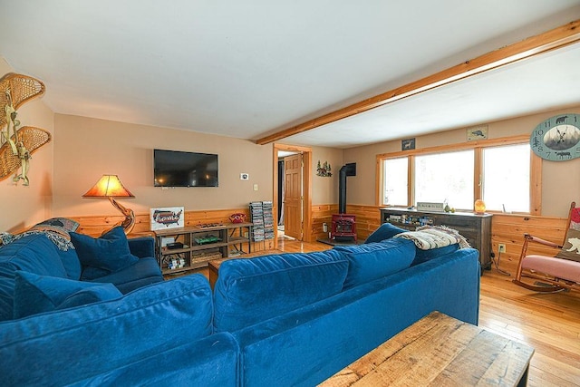 living room featuring a wood stove, wooden walls, and light wood-type flooring