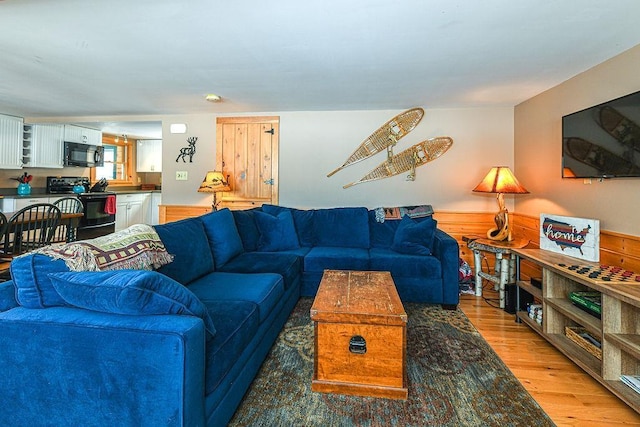 living room featuring hardwood / wood-style flooring and wooden walls