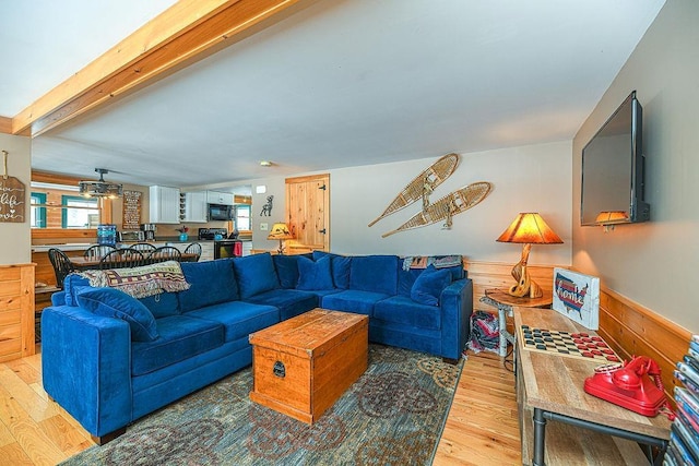 living room with beam ceiling, hardwood / wood-style floors, and wooden walls