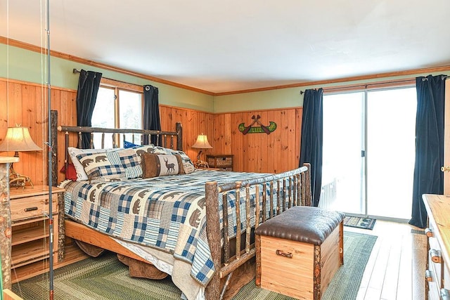 bedroom featuring crown molding, hardwood / wood-style floors, and access to exterior