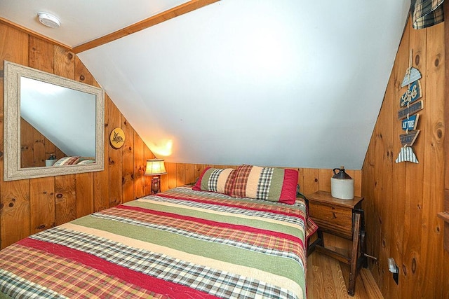 bedroom featuring lofted ceiling, hardwood / wood-style flooring, and wooden walls