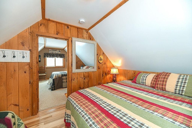 bedroom with lofted ceiling, light wood-type flooring, and wood walls