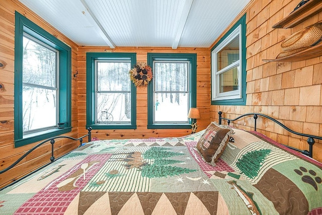 unfurnished bedroom with beam ceiling and wood walls