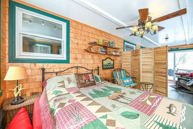 bedroom featuring access to exterior and wood walls