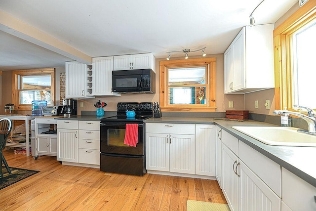 kitchen featuring white cabinetry, sink, and black appliances