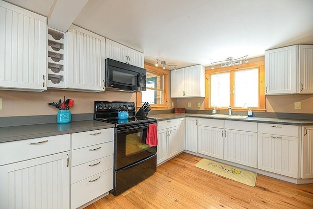 kitchen with white cabinetry, sink, black appliances, and light hardwood / wood-style floors