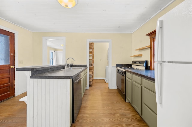 kitchen featuring sink, green cabinets, stainless steel gas stove, white refrigerator, and light hardwood / wood-style floors