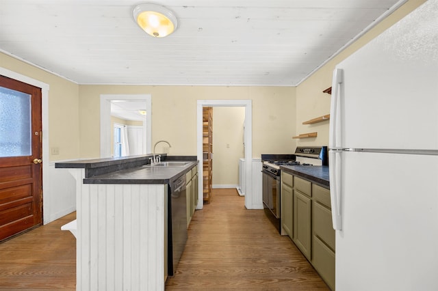 kitchen with appliances with stainless steel finishes, a kitchen bar, sink, and light wood-type flooring