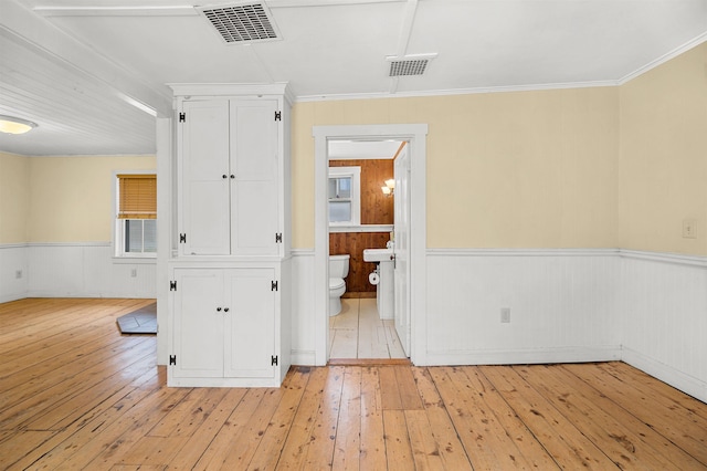 empty room featuring crown molding and light hardwood / wood-style floors