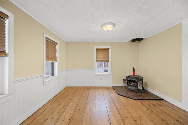 interior space with hardwood / wood-style flooring, wooden ceiling, and a wood stove