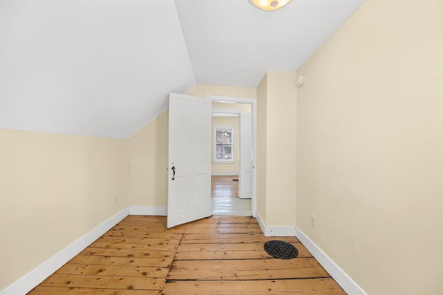 additional living space with vaulted ceiling and light wood-type flooring