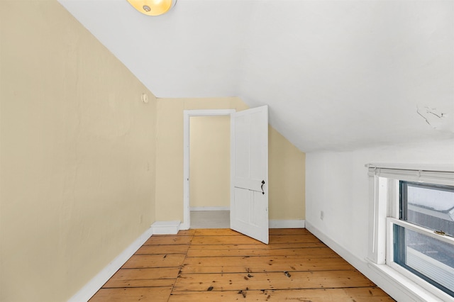 bonus room with hardwood / wood-style flooring and vaulted ceiling