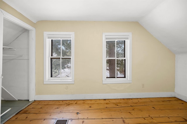 bonus room featuring lofted ceiling, wood-type flooring, and plenty of natural light