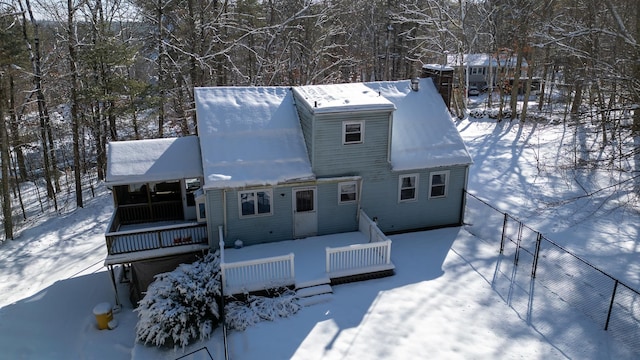 snow covered rear of property featuring covered porch