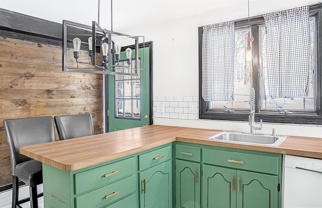 kitchen featuring sink, kitchen peninsula, dishwasher, and green cabinets