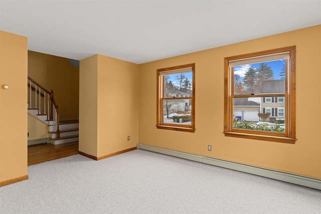 carpeted empty room with a baseboard radiator and plenty of natural light