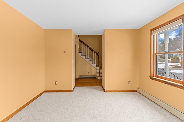 carpeted empty room featuring a baseboard radiator