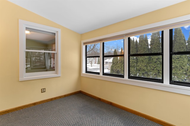 carpeted spare room featuring vaulted ceiling