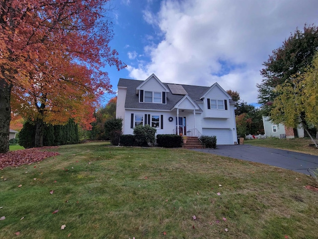 view of front of property featuring a garage and a front lawn