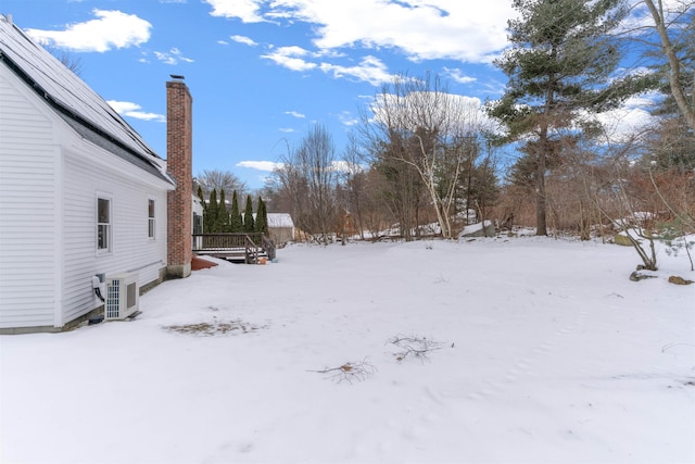 yard covered in snow featuring ac unit