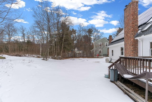 yard covered in snow featuring a deck