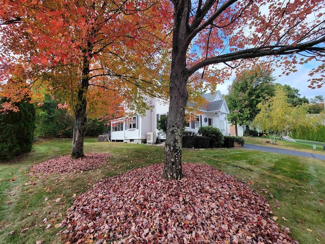 view of front of property with central AC and a front lawn