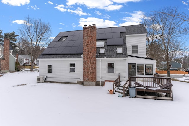 snow covered house with ac unit and solar panels