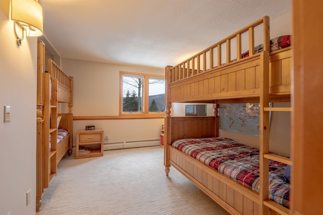 bedroom with a baseboard heating unit, light colored carpet, and a textured ceiling