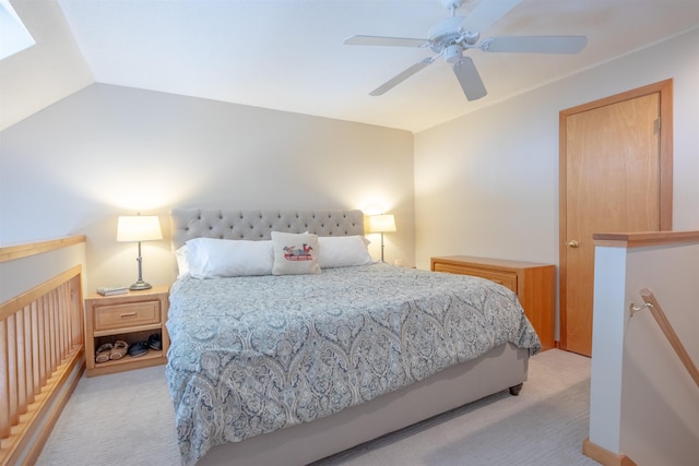 bedroom with ceiling fan, vaulted ceiling, and light carpet