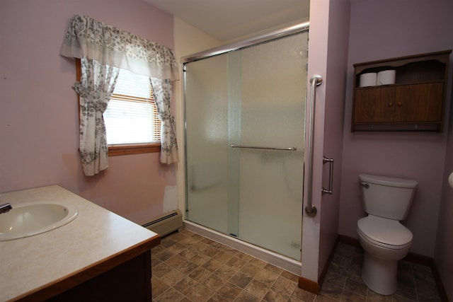 bathroom with vanity, toilet, a shower with door, and a baseboard heating unit