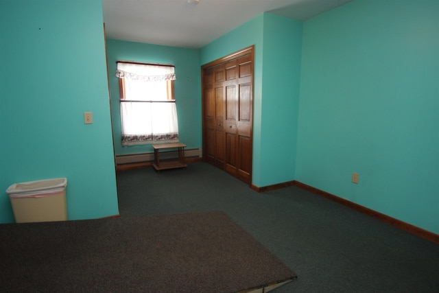 unfurnished bedroom featuring baseboard heating, a closet, and carpet