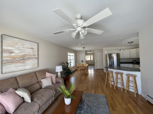 living room with a baseboard radiator, dark hardwood / wood-style floors, and ceiling fan