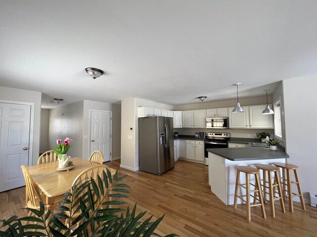 kitchen featuring sink, white cabinets, a kitchen breakfast bar, kitchen peninsula, and stainless steel appliances