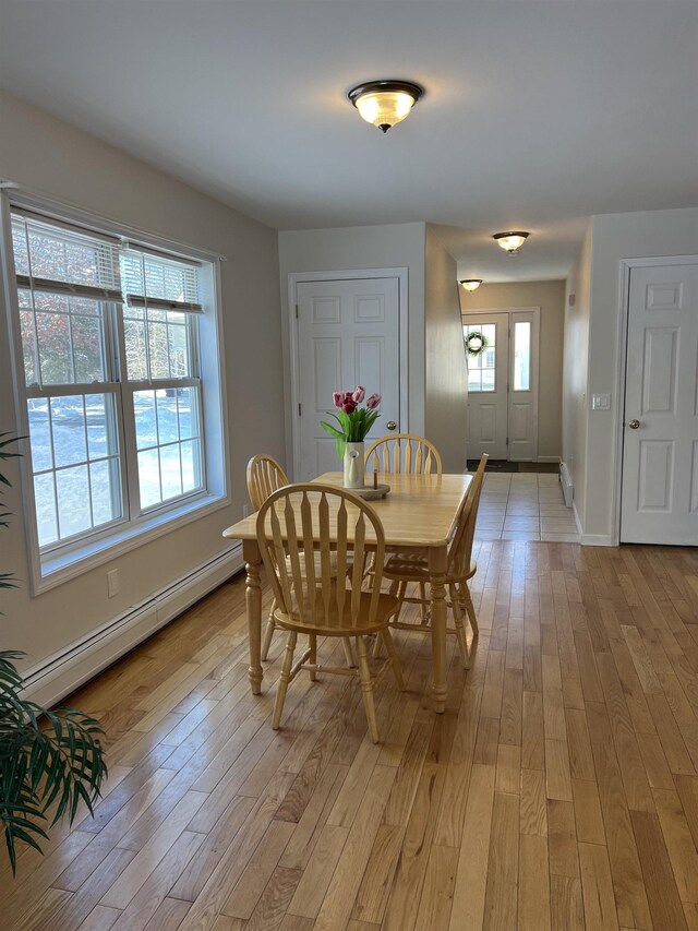 dining room with a baseboard heating unit and light hardwood / wood-style floors