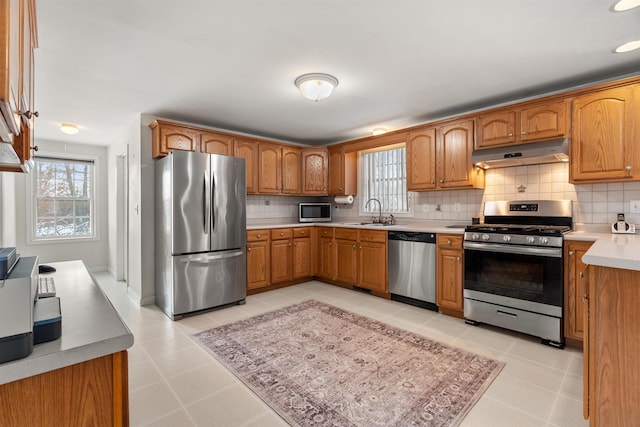 kitchen with stainless steel appliances, a wealth of natural light, and backsplash