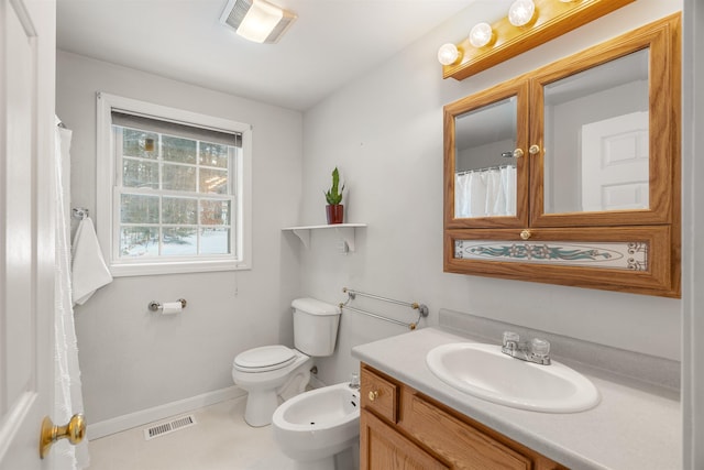 bathroom featuring a bidet, vanity, and toilet