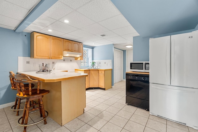 kitchen with dishwasher, kitchen peninsula, white fridge, and light brown cabinets