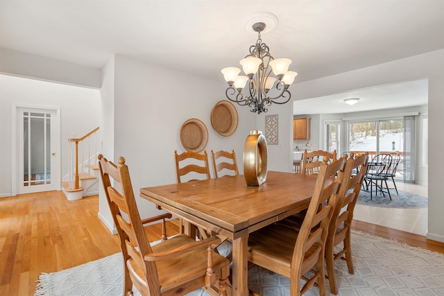 dining area featuring a notable chandelier and light wood-type flooring