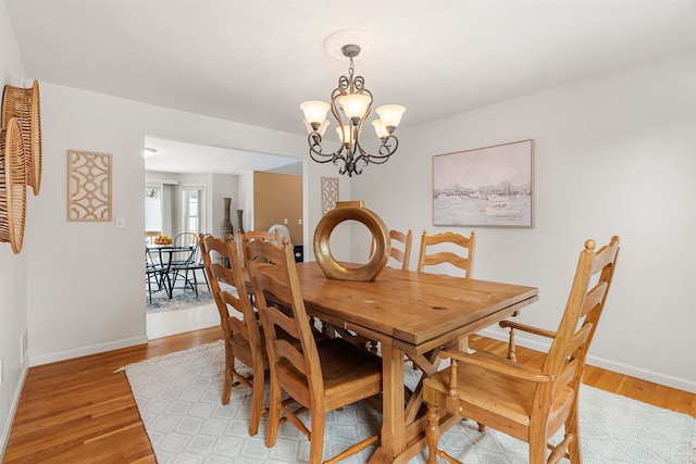 dining space featuring an inviting chandelier and light hardwood / wood-style floors