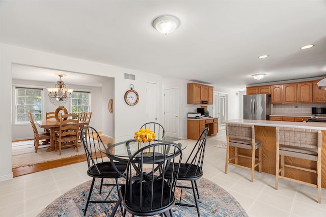 tiled dining space with a chandelier