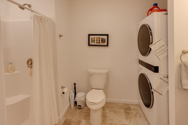 bathroom with curtained shower, toilet, and stacked washer / dryer