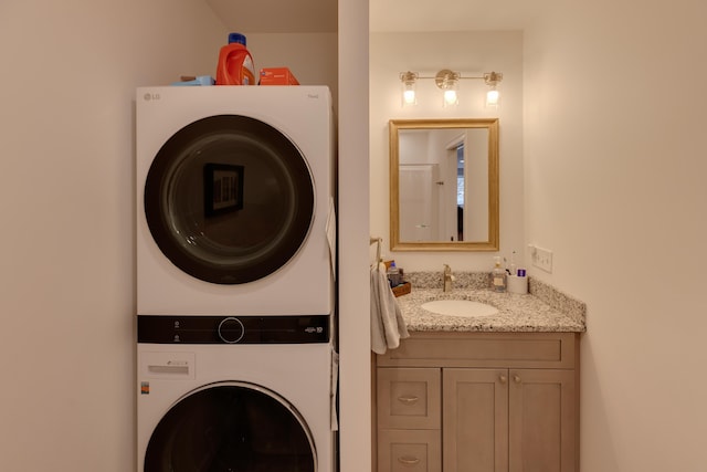 clothes washing area with sink and stacked washer and dryer