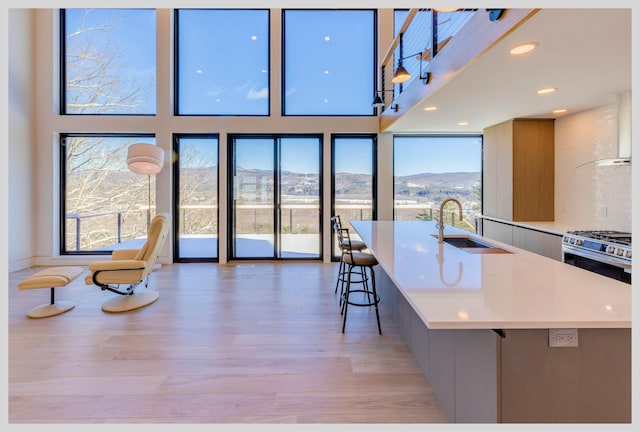 kitchen featuring plenty of natural light, a spacious island, a kitchen bar, a mountain view, and wall chimney exhaust hood