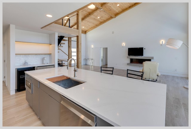 kitchen featuring sink, wine cooler, light hardwood / wood-style floors, wooden ceiling, and stainless steel dishwasher