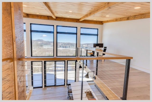 home office with wood ceiling, beam ceiling, a mountain view, and hardwood / wood-style floors