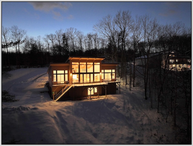 snow covered house with a wooden deck