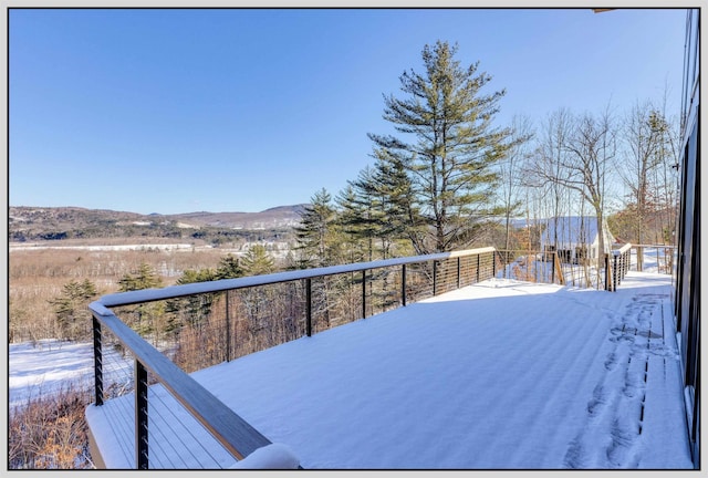 snow covered deck with a mountain view