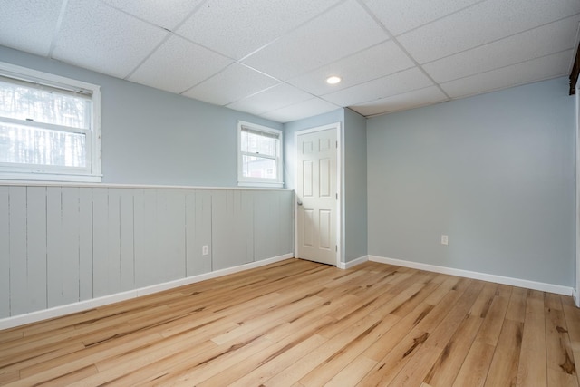 interior space featuring a paneled ceiling and light hardwood / wood-style floors