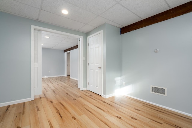 unfurnished room featuring a paneled ceiling and light wood-type flooring